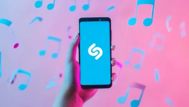 Akıllı telefon ekranında Shazam logosu ve uçuşan müzik notaları illüstrasyonu.