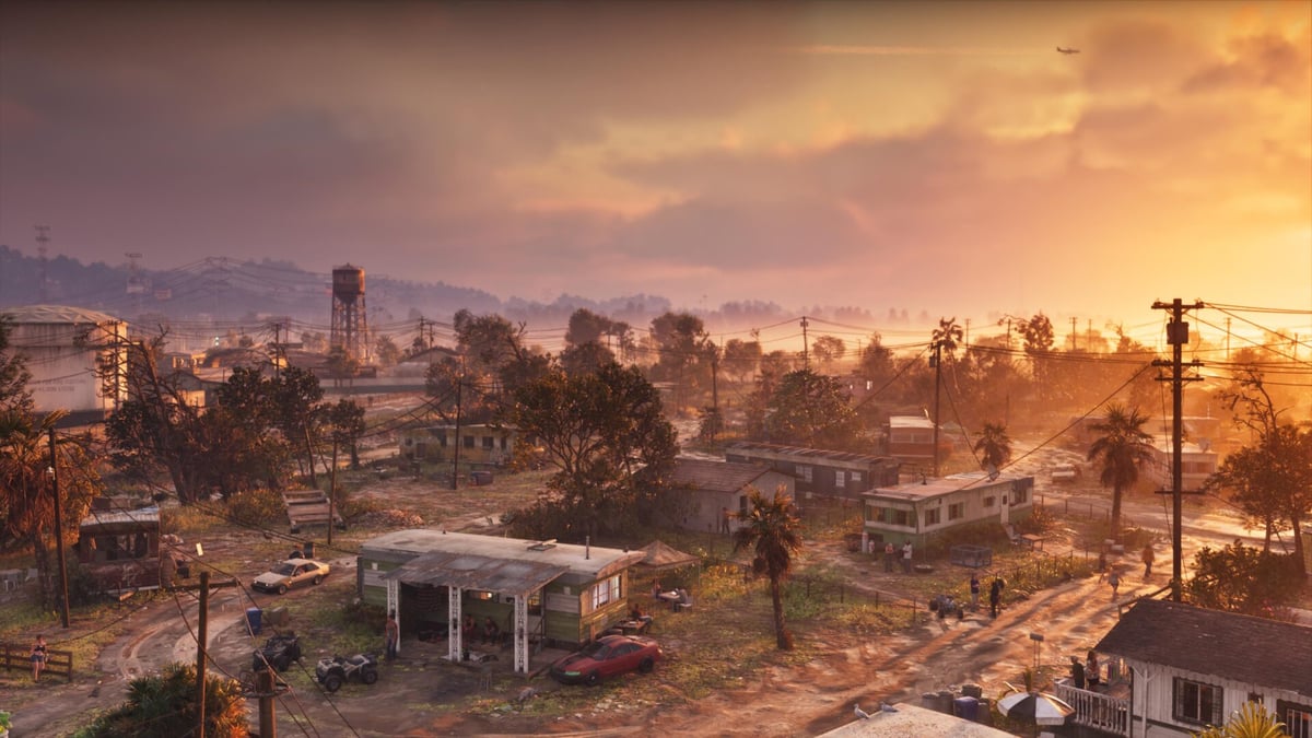 GTA 6 için Yeni Resmi Görseller Paylaşıldı Gün batımı ışığında karavan evler, toprak yollar ve palmiye ağaçlarının yer aldığı kırsal alan manzarası.